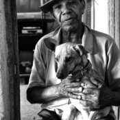 <i class="fa-regular fa-image orange1"></i> Seu Antônio (68 anos) e Lobinho, quilombo Campo, Serranópolis de Minas, MG. / <em>Seu Antônio (68 years old), Quilombo de Campo, an old settlement founded by Maroons, Serranopolis de Minas, Minas Gerais.</em> Edu Moreira - Caatingueiros
