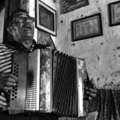 <i class="fa-regular fa-image orange1"></i> Sanfoneiro, Geraldo (55 anos), alfabetizado tardiamente, é um autodidata. Os diplomas na parede de sua casa são motivo de grande orgulho. Comunidade de Touros, Serranópolis de Minas, MG. / <em>Accordion player, Geraldo (55 years old), late literate and self-educated. The diplomas on the his house walls are a source of great pride. Touros Village, Serranopolis de Minas, Minas Gerais.</em> Edu Moreira - Caatingueiros