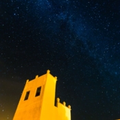 <i class="fa-regular fa-image orange1"></i> Vista da Via Láctea sobre o céu de Merzouga, uma pequena aldeia Berbére no deserto do Saara (Marrocos). / <em>View of the Milky Way over the sky of Merzouga, a small Berber village in the Sahara desert (Morocco).</em> Edu Moreira - Marrocos
